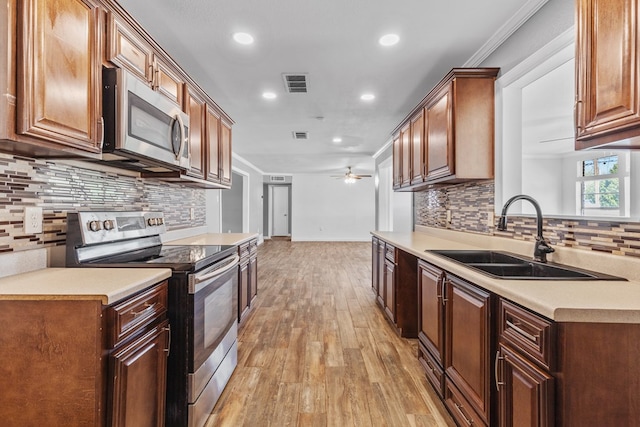 2616 E 21st St, Odessa, TX 79761 - kitchen featuring stainless steel appliances, a sink, light wood-style flooring, tasteful backsplash, and recessed lighting