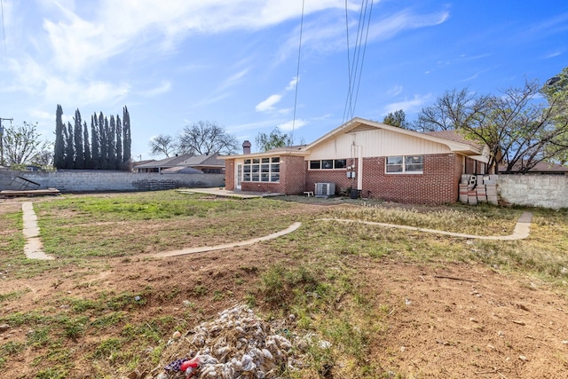 2616 E 21st St, Odessa, TX 79761 - back of house featuring brick siding, central AC unit, and a chimney