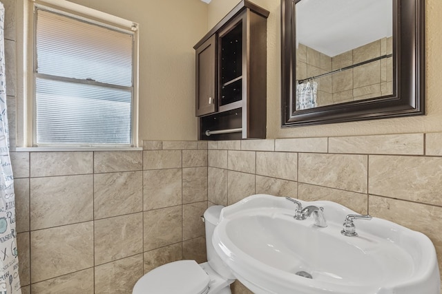 2616 E 21st St, Odessa, TX 79761 - full bath with tile walls, toilet, a sink, a shower with curtain, and wainscoting