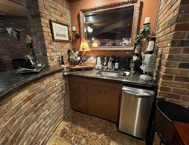 bar with a sink, stainless steel dishwasher, brick wall, and indoor wet bar