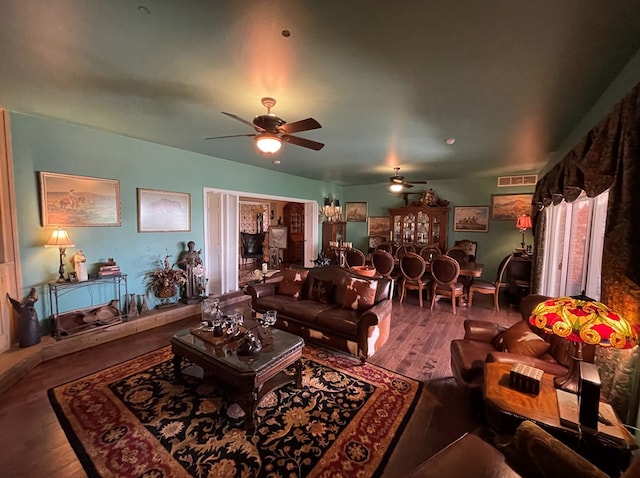 living area featuring visible vents, a ceiling fan, and wood finished floors