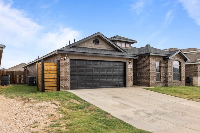 609 E 96th Ct, Odessa, TX 79765 - view of front of home with brick siding, central air condition unit, a garage, and driveway