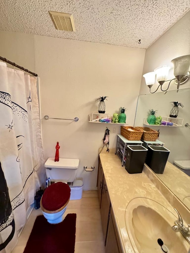 bathroom featuring curtained shower, visible vents, toilet, vanity, and a textured ceiling