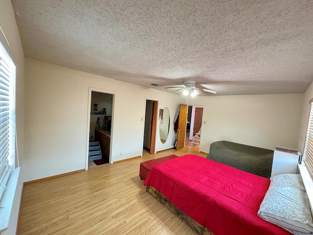 bedroom featuring a textured ceiling, wood finished floors, a ceiling fan, and baseboards