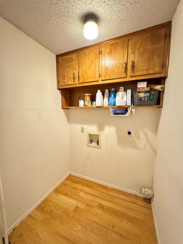 clothes washing area with washer hookup, cabinet space, electric dryer hookup, light wood-type flooring, and baseboards