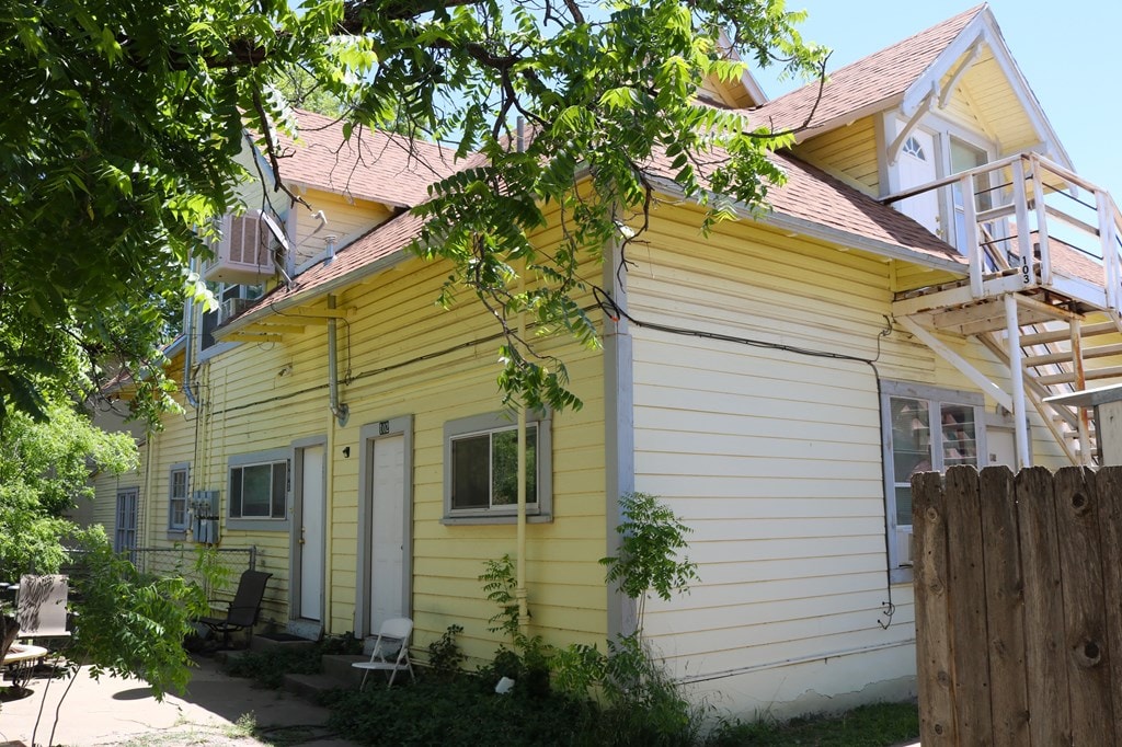 805 E Holland Ave, Alpine, TX 79830 - view of side of property with roof with shingles, a balcony, and fence