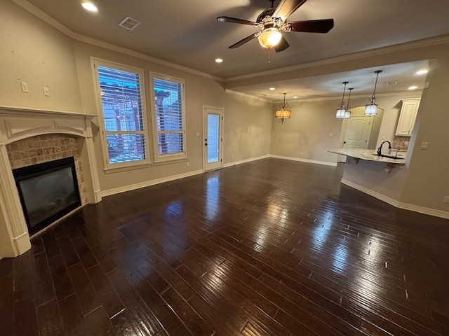1205 Silverton Dr, Midland, TX 79705 - unfurnished living room featuring a ceiling fan, a fireplace, recessed lighting, dark wood-style floors, and ornamental molding