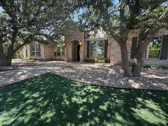 1205 Silverton Dr, Midland, TX 79705 - obstructed view of property featuring brick siding and a front yard