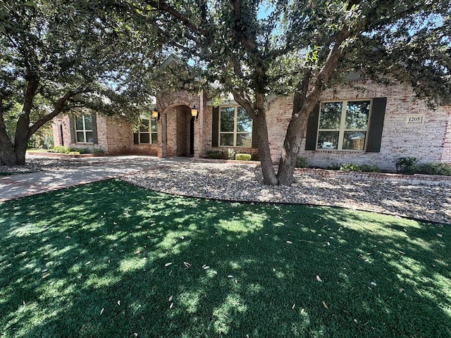 1205 Silverton Dr, Midland, TX 79705 - view of property hidden behind natural elements featuring a front yard and brick siding