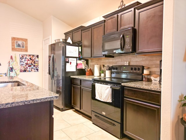 kitchen featuring a sink, light tile patterned floors, lofted ceiling, tasteful backsplash, and black appliances