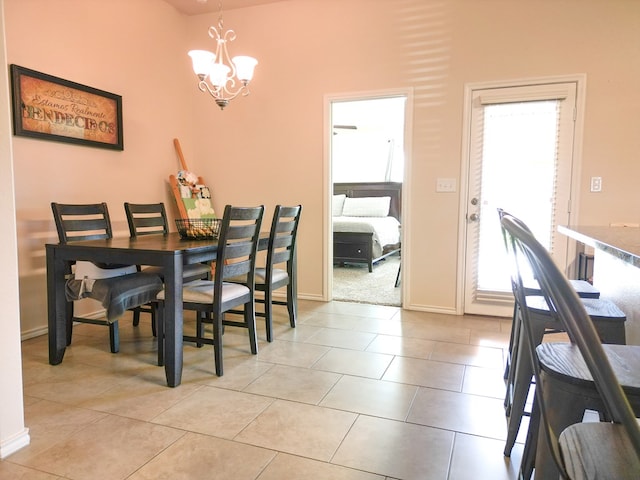 dining area with baseboards, light tile patterned flooring, and a notable chandelier
