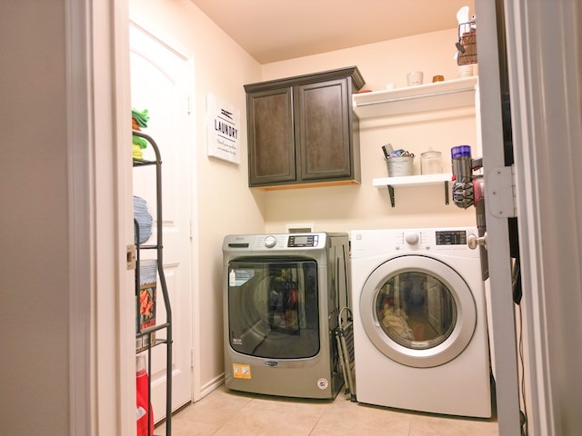 washroom featuring light tile patterned floors, separate washer and dryer, and cabinet space