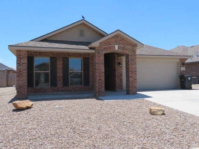 1812 Masquerade Blvd, Odessa, TX 79765 - view of front of house with brick siding, concrete driveway, an attached garage, and roof with shingles