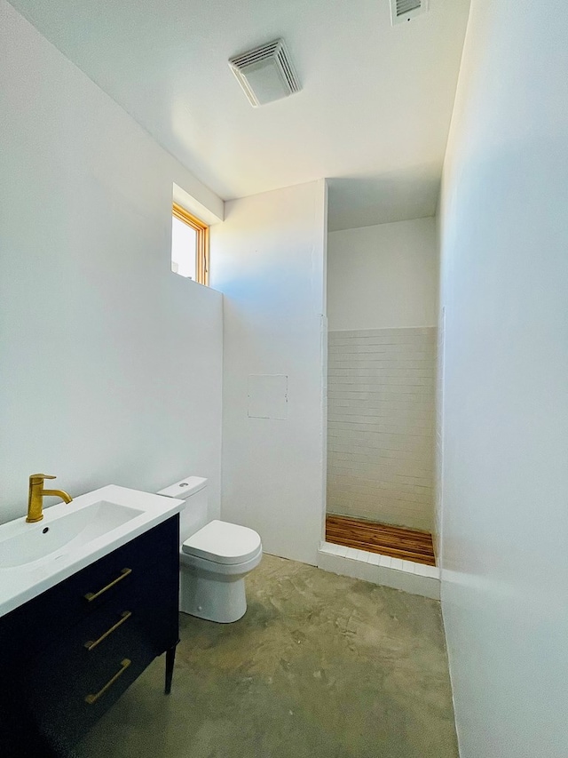 702 E Washington St, Marfa, TX 79843 - bathroom with toilet, tiled shower, vanity, and visible vents
