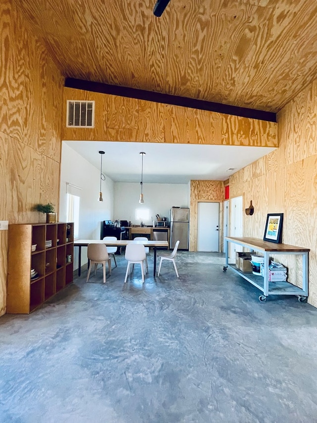 702 E Washington St, Marfa, TX 79843 - interior space featuring freestanding refrigerator, wooden walls, and visible vents