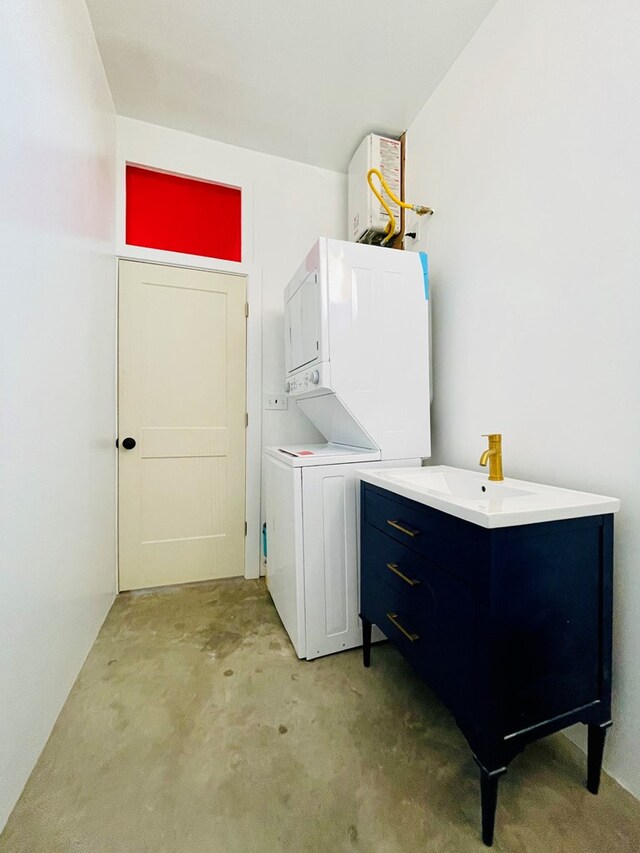 702 E Washington St, Marfa, TX 79843 - clothes washing area with light colored carpet, stacked washing maching and dryer, a sink, and laundry area