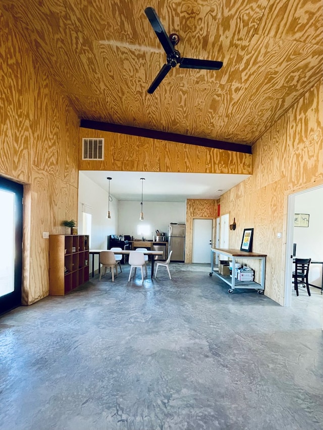 702 E Washington St, Marfa, TX 79843 - garage with freestanding refrigerator, wooden walls, ceiling fan, and visible vents