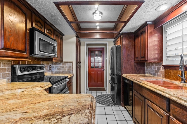 1324 Pagewood Ave, Odessa, TX 79761 - kitchen with stainless steel appliances, a textured ceiling, light tile patterned floors, decorative backsplash, and light stone counters