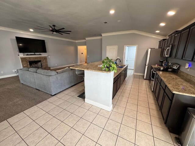 616 96th St, Odessa, TX 79765 - kitchen with appliances with stainless steel finishes, a ceiling fan, crown molding, light stone countertops, and light tile patterned floors