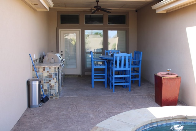 view of patio with a ceiling fan, exterior kitchen, and outdoor dining space
