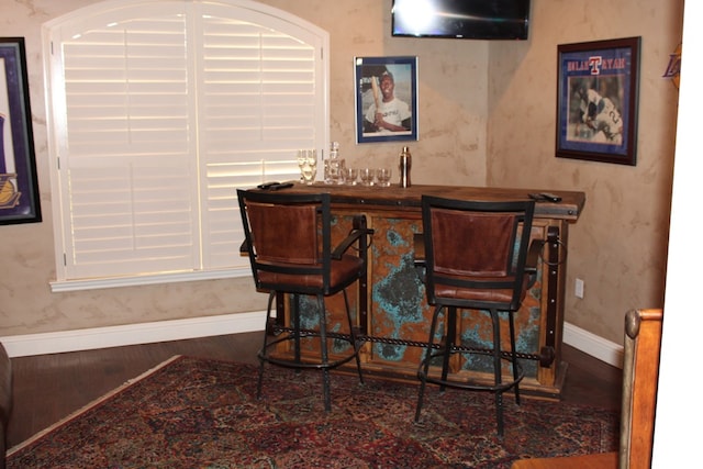 indoor wet bar with baseboards and wood finished floors