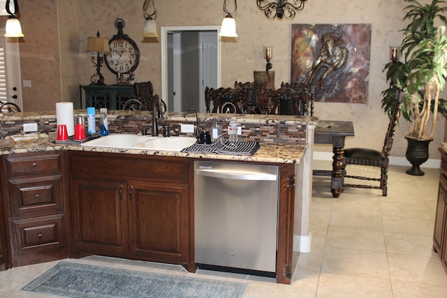 kitchen with dishwasher, a sink, light tile patterned floors, pendant lighting, and decorative backsplash