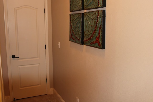 hallway with tile patterned flooring and baseboards