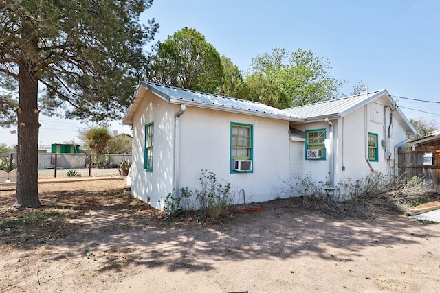 408 W 2nd St, Marfa, TX 79843 - view of property exterior featuring fence, stucco siding, metal roof, and cooling unit
