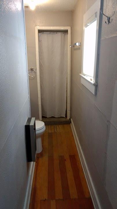 408 W 2nd St, Marfa, TX 79843 - full bathroom with hardwood / wood-style flooring, toilet, and a shower with curtain