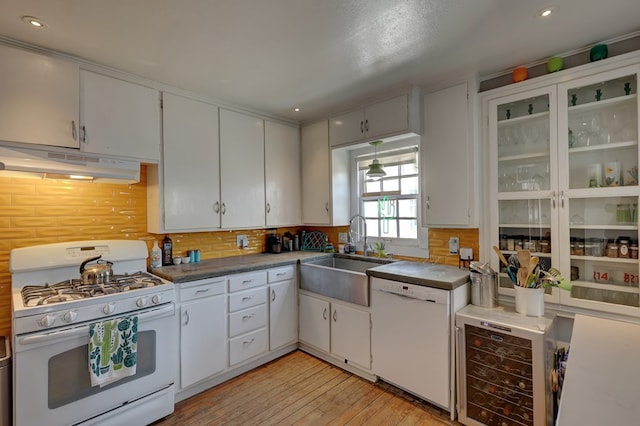 408 W 2nd St, Marfa, TX 79843 - kitchen featuring white appliances, under cabinet range hood, a sink, wine cooler, and backsplash