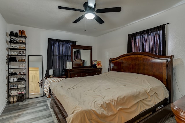 bedroom featuring a textured ceiling, ceiling fan, and light hardwood / wood-style flooring