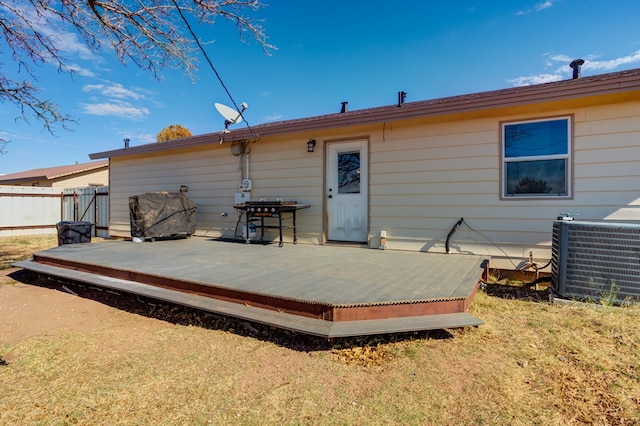 back of property with a deck and central AC