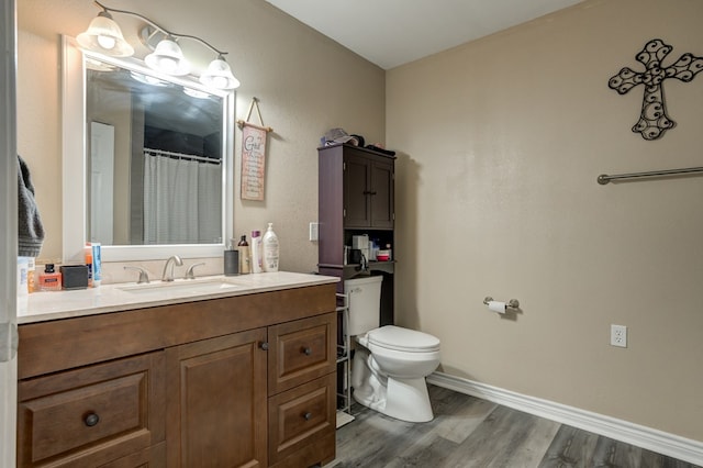 bathroom featuring toilet, vanity, and wood-type flooring