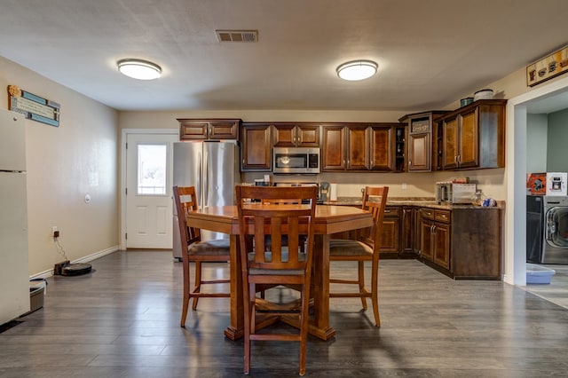 dining space featuring dark hardwood / wood-style flooring and washer / clothes dryer