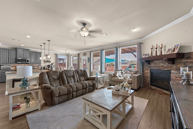 7028 Xit Ranch Rd, Odessa, TX 79765 - living room with crown molding, ceiling fan, a textured ceiling, healthy amount of natural light, and wood finished floors
