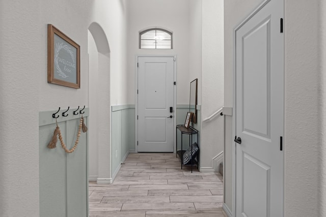 entryway featuring light wood-style floors and a textured wall