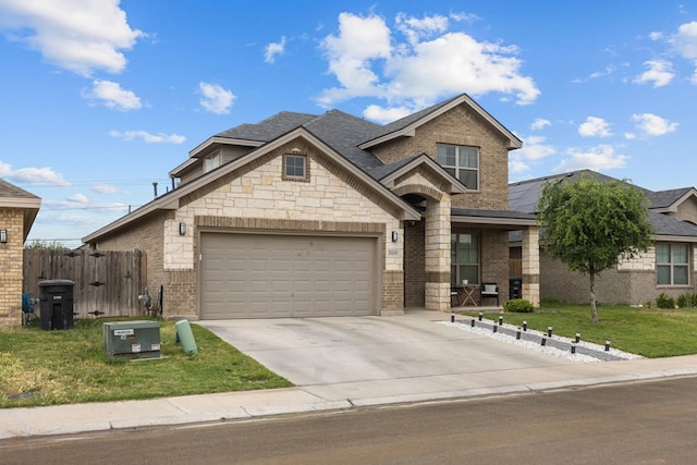view of front facade with fence, an attached garage, brick siding, driveway, and a front lawn