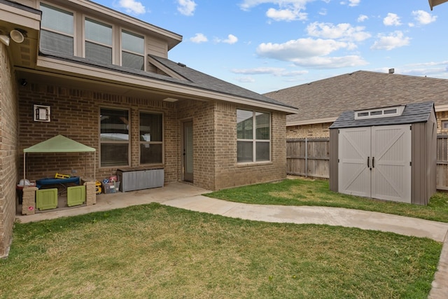 rear view of house featuring a fenced backyard, a storage shed, brick siding, and a lawn
