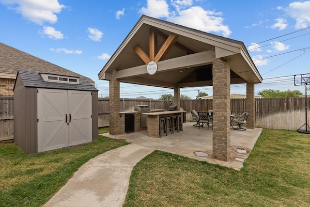 view of patio / terrace featuring an outbuilding, a shed, outdoor dry bar, a gazebo, and a fenced backyard