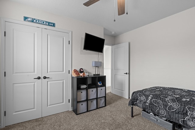 bedroom featuring a ceiling fan, a closet, and carpet