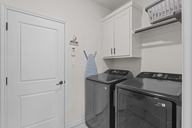 laundry room featuring cabinet space, washing machine and dryer, and baseboards
