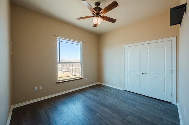 unfurnished bedroom with dark wood-type flooring, a closet, and ceiling fan