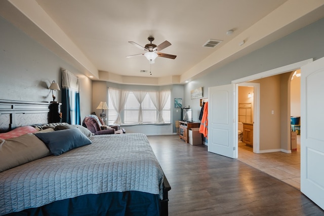 bedroom featuring ceiling fan, ensuite bathroom, and hardwood / wood-style floors