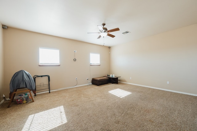 empty room with ceiling fan and light carpet