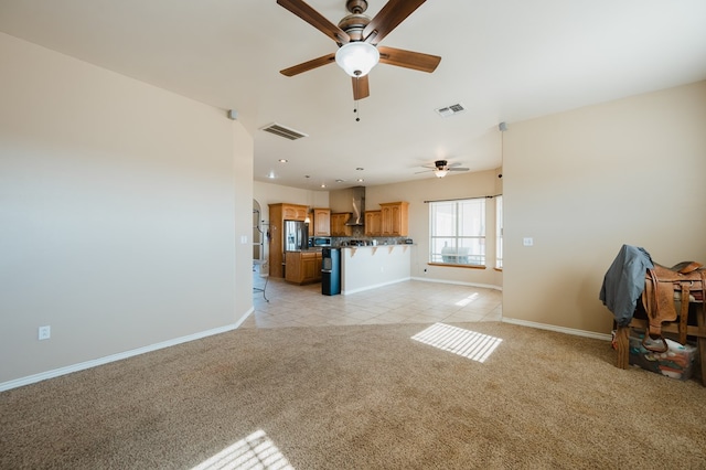 unfurnished living room with ceiling fan and light carpet