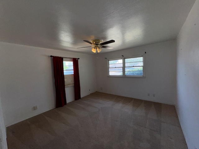 spare room featuring a healthy amount of sunlight, ceiling fan, and light colored carpet