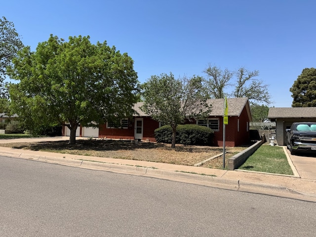 view of front of home with brick siding, a garage, and driveway