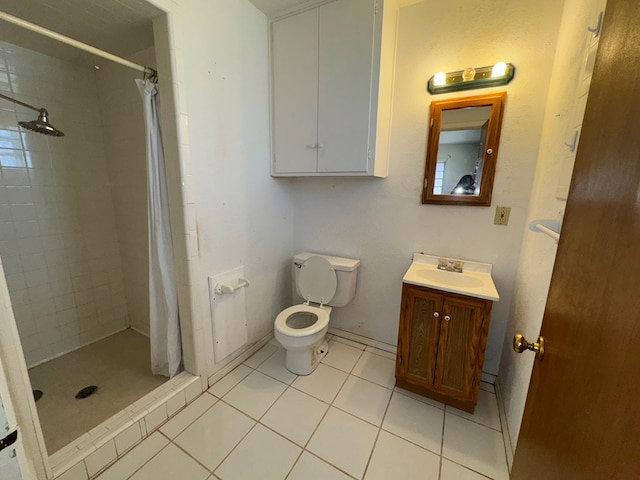 bathroom featuring vanity, toilet, tile patterned flooring, and a stall shower