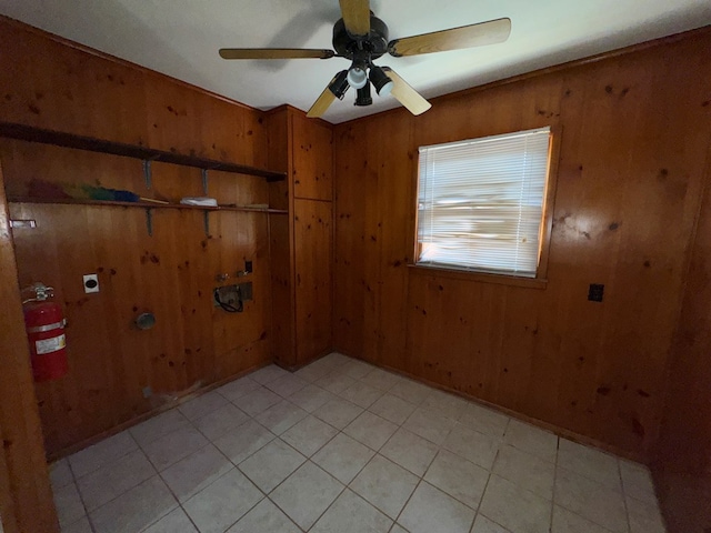 spare room featuring a ceiling fan and wood walls