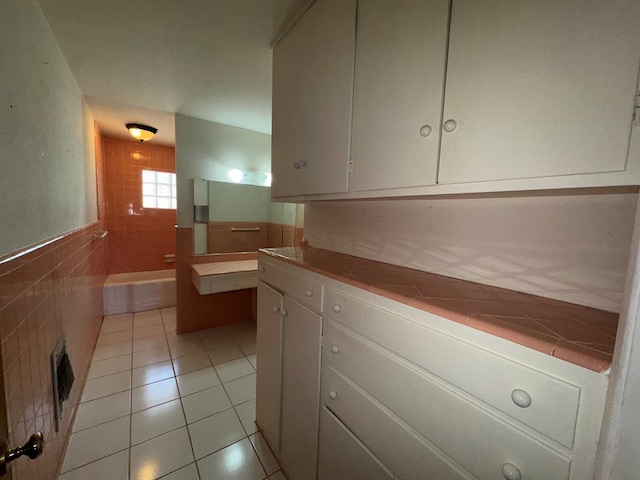 full bathroom with a bathtub, visible vents, tile patterned flooring, wainscoting, and vanity